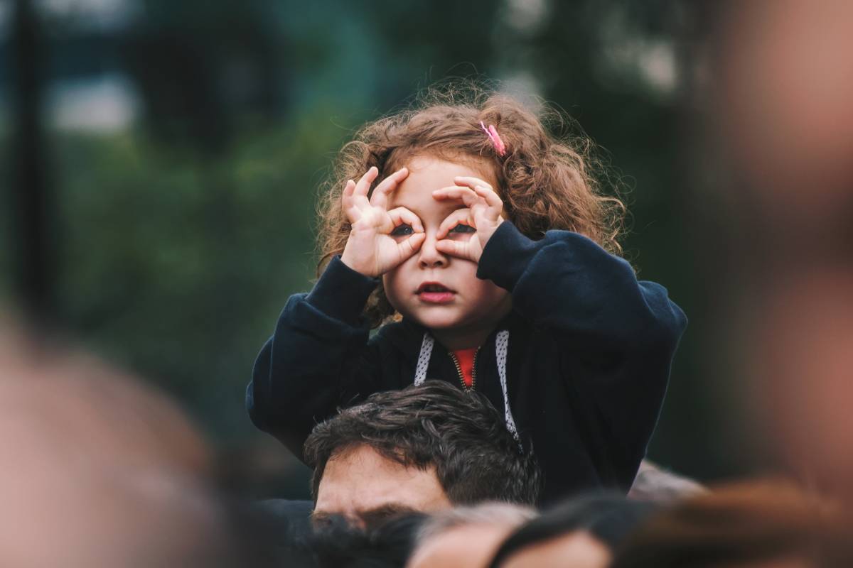 Petite fille faisant des lunettes avec ses doigts