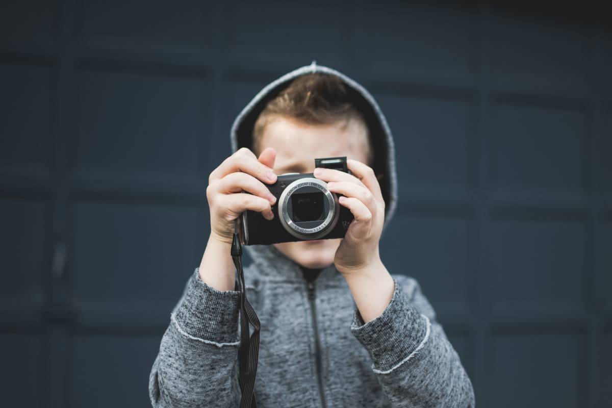 Enfant avec un appareil photo devant son visage